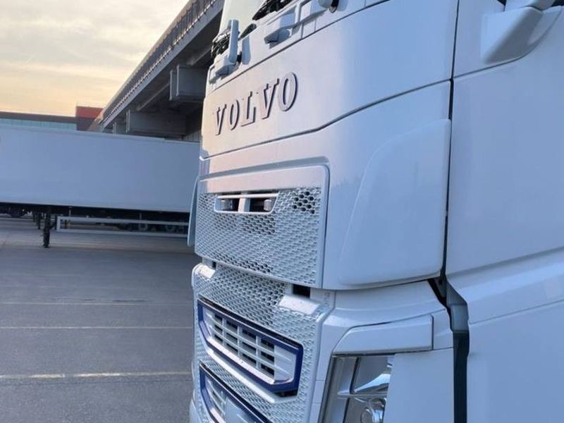Белый тягач Volvo на стоянке у склада